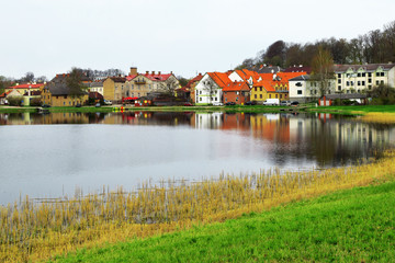 Fototapeta na wymiar Beautiful old town houses with lake reflection in spring morning in Talsi Latvia.