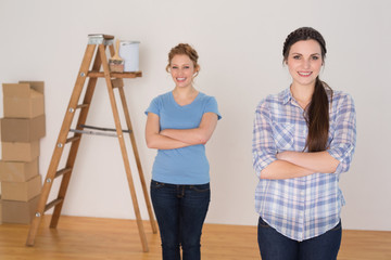 Friends standing with arms crossed in a new house