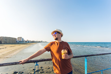 man with coffee frappe looking the sea feeling free enjoying freetime vacations