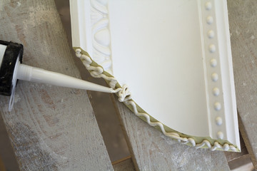 Close-up detail of decoration molding with glue adhesive before installation in interior renovation. © bilanol
