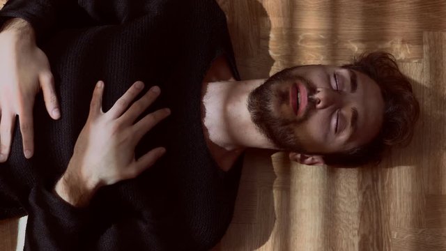 panic attack.Young man anxious and stressed lying on the floor in the dark