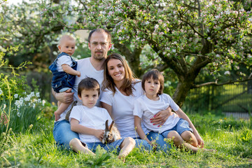 Fototapeta na wymiar Fashionable big family, having their spring portrait taken with little bunnies
