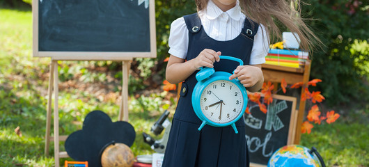 Portrait of a beautiful young first-grader standing with books