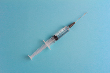 Syringe with medication on a blue background