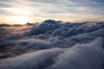 Beautiful and striking aerial view of the puffy clouds during a colorful sunset. Taken near Vancouver, British Columbia, Canada.