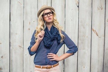 Day dreaming trendy blonde holding pencil