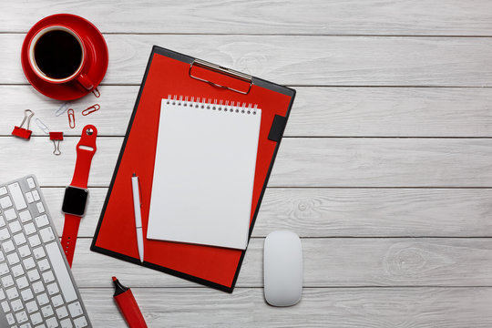 white desk boards folder red notepad cup of coffee clock paper clips keyboard mouse workflow