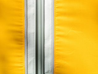Yellow tarpaulin or polymeric fabric fastened with a zipper. Copy space.