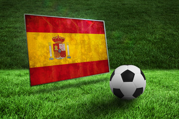Fototapeta premium Black and white football on grass against spain flag in grunge effect