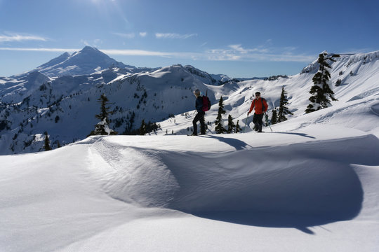 Adventurous man and woman are snowshoeing in the snow. Taken in Artist Point, Northeast of Seattle, Washington, United States of America.