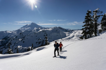 Fototapeta na wymiar Adventurous man and woman are snowshoeing in the snow. Taken in Artist Point, Northeast of Seattle, Washington, United States of America.