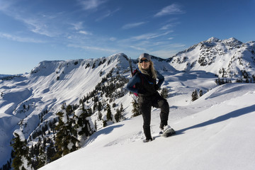 Fototapeta na wymiar Adventurous woman is snowshoeing in the beautiful mountainous landscape. Taken in Artist Point, Northeast of Seattle, Washington, United States of America.
