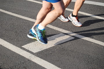 Corrida, pés de duas pessoas a correr em pista de corrida com sapatilhas calçadas, praticar desporto, maratona © ajcsm