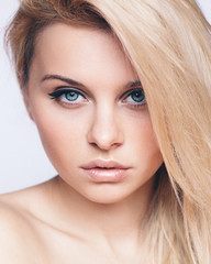 Headshot of teenage girl with blonde hair, blue eyes and smooth fresh clean skin, looking at the camera.  People and lifestyle concept