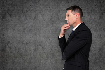 Businessman thinking against grey background