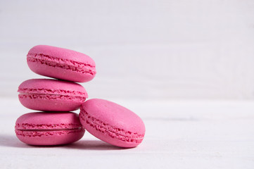 Obraz na płótnie Canvas Cake macaron pink pastel color on white wooden background