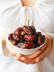 Dates palm in women's hands. The concept of healthy eating.