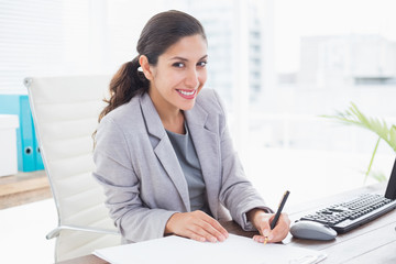 Smiling businesswoman writing notes