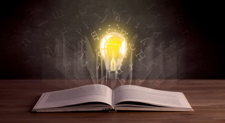 Shiny alphabet letters and yellow lightbulb hovering over open book 