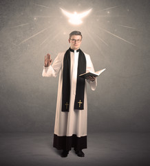 A holy priest reading a prayer from the holy bible with illustrated glowing angel above his head...