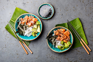 Salmon sushi bowl or salmon poce with soy sauce. Top view. Gray slate background