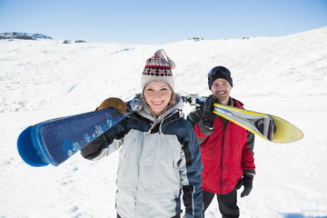 Fototapeta na wymiar Portrait of a smiling couple with ski boards on snow