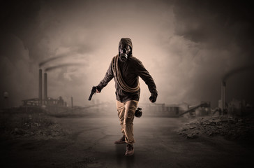 Fototapeta na wymiar Gas masked survival man coming with arms on his hand in a demolished dark environment 
