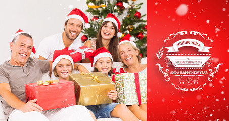 Happy family at christmas holding gifts against red vignette