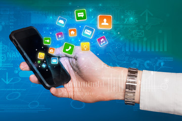 Hand using phone with bouncing colorful application and global reports and graphs concept
