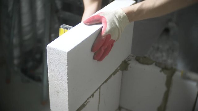 a construction site, a builder puts a wall of gas blocks. 4k.