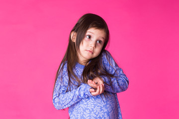 Portrait of a charming brunette little child girl, isolated on pink background