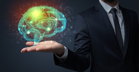 Businessman holding human brain on his hand with logistics symbols around