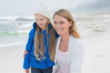 Cute girl with smiling mother at beach