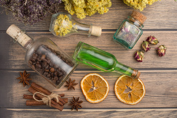 Aromatic oil, grains of coffee, aroma of grass in glass bottles, on a wooden background. The concept of body care and beauty