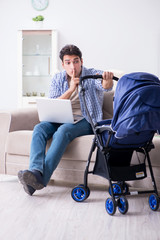 Young father looking after newborn baby at home