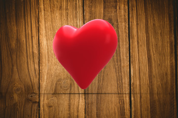 Red heart against wooden table