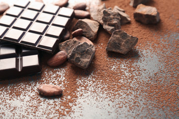 Composition with cocoa powder and chocolate on grey background