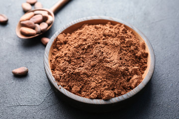 Plate with cocoa powder on grey background