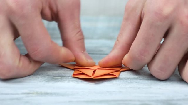 Hands folding origami space ship close up. Origami rocket ship tutorial. Easy paper origami rocket ship.