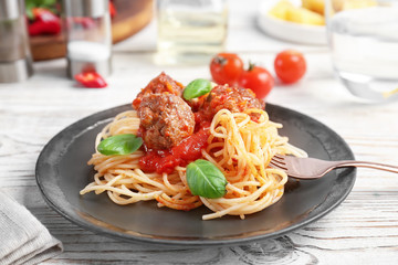 Delicious pasta with meatballs and tomato sauce on wooden table