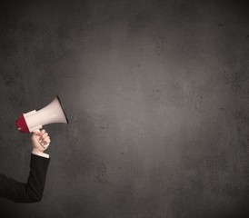 Caucasian arm holding megaphone with plain grunge background