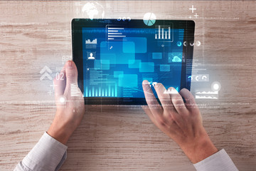 Caucasian business hands holding tablet with blue business-statistics screen