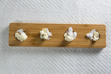 Overhead view of cauliflowers with cheese on cutting board