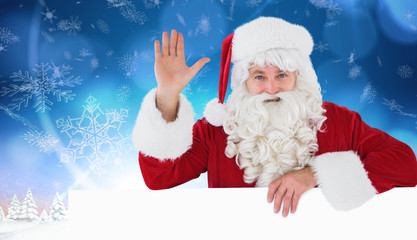 Portrait of santa claus waving against snowy landscape with fir trees