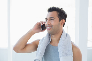 Fit young smiling man using mobile phone