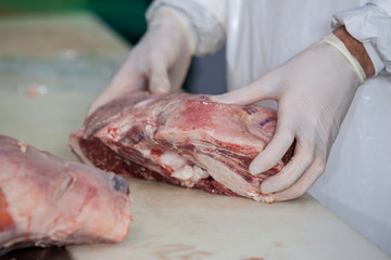 Butcher holding raw meat at meat factory