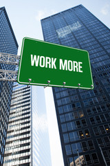Obraz premium The word work more and green billboard sign against low angle view of skyscrapers