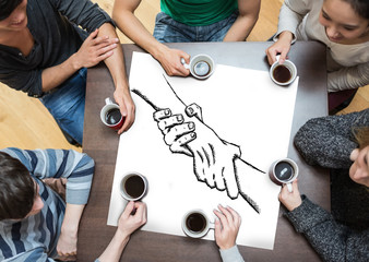 People sitting around table drinking coffee with page showing hands touching