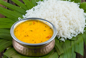 Indian Traditional Cuisine Dal Fry or Rice Also Know as Dal Chawal, Daal Chawal, Dal Rice, Whole Yellow Lentil with Rice or Dal Tadka, Daal Fry Served with Rice on Wooden Background  - obrazy, fototapety, plakaty