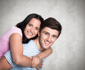 Young couple smiling at the camera against weathered surface 